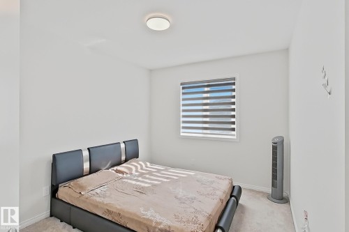 Bright bedroom featuring light-colored walls and soft carpeting - 1231 Watt Drive, Edmonton, AB - Indoor Photo Showing Bedroom