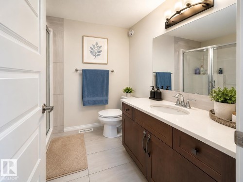 Bathroom featuring a dark wood-finish vanity with a light countertop, an undermount sink, and a large mirror - 1231 Watt Drive, Edmonton, AB - Indoor Photo Showing Bathroom