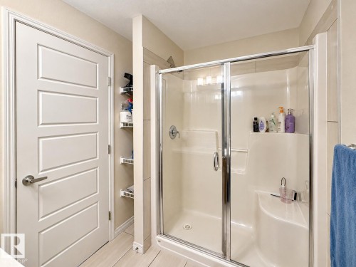 Walk-in shower with clear glass enclosure and integrated seating - 1231 Watt Drive, Edmonton, AB - Indoor Photo Showing Bathroom