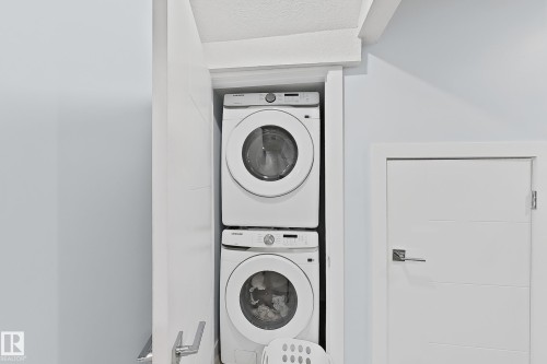 Dedicated laundry closet featuring a stacked washer and dryer - 1231 Watt Drive, Edmonton, AB - Indoor Photo Showing Laundry Room