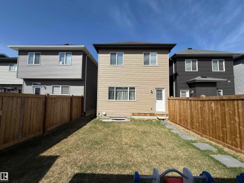 Rear exterior featuring tan horizontal siding and white trim - 1231 Watt Drive, Edmonton, AB - Outdoor With Exterior