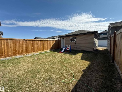 Private backyard with a detached accessory building featuring neutral siding, a single window, and an exterior door - 1231 Watt Drive, Edmonton, AB - Outdoor