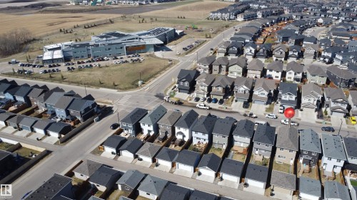 Aerial perspective showcasing a developed residential area with numerous detached properties and a contemporary institutional building - 1231 Watt Drive, Edmonton, AB -  With View