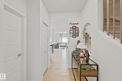 Light-toned wood-finish flooring extending from the entryway - 1231 Watt Drive, Edmonton, AB - Indoor Photo Showing Other Room