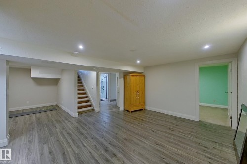 Spacious finished area featuring wood-finish flooring, recessed lighting, and white baseboards - 10 Brunswick Crescent, St. Albert, AB - Indoor