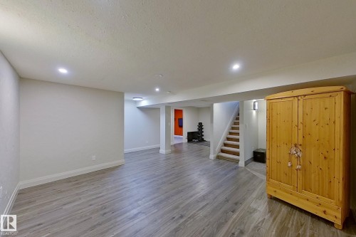 Spacious lower level featuring wood-finish flooring, recessed lighting, painted walls, and a finished staircase with carpeted treads - 10 Brunswick Crescent, St. Albert, AB - Indoor