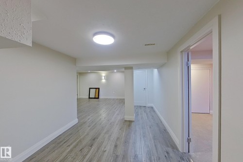 Finished lower level featuring wood-finish flooring, recessed lighting, and wall sconces - 10 Brunswick Crescent, St. Albert, AB - Indoor Photo Showing Other Room