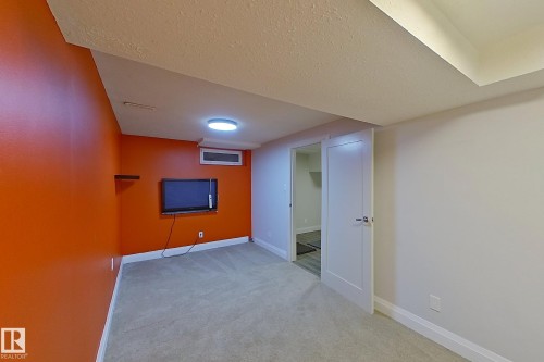 Carpeted room featuring a ceiling-mounted light fixture, recessed lighting, white baseboards, and a wall-mounted shelving unit - 10 Brunswick Crescent, St. Albert, AB - Indoor