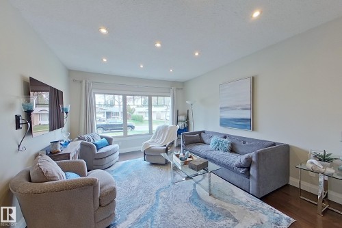 Spacious living area featuring expansive windows, recessed lighting, hardwood flooring, and light-toned walls - 10 Brunswick Crescent, St. Albert, AB - Indoor Photo Showing Living Room