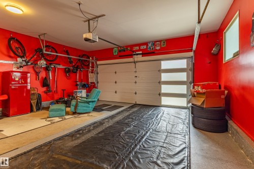 Garage featuring a modern sectional garage door with frosted glass panels, a single window, overhead lighting, and concrete flooring - 10 Brunswick Crescent, St. Albert, AB - Indoor Photo Showing Garage