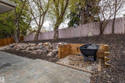 Paved patio with a rock wall, a wood-sided planter box, and mature trees - 10 Brunswick Crescent, St. Albert, AB - Outdoor