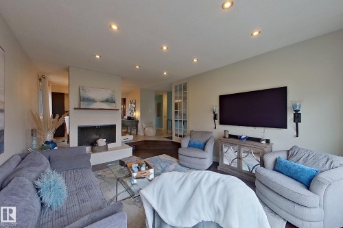 Spacious living area featuring a brick fireplace with a mantle, recessed lighting, and dark wood-finish flooring - 10 Brunswick Crescent, St. Albert, AB - Indoor Photo Showing Living Room With Fireplace