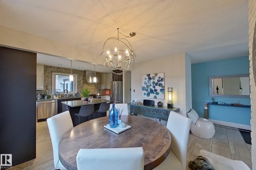 Open-concept dining area featuring a contemporary spherical chandelier and wood-finish flooring - 10 Brunswick Crescent, St. Albert, AB - Indoor Photo Showing Dining Room