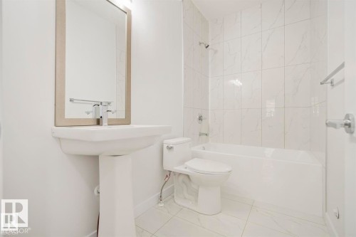 Bright bathroom featuring a pedestal sink, framed mirror, and a modern toilet - 151 Kidd Crescent, Leduc, AB - Indoor Photo Showing Bathroom
