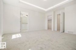 Spacious room featuring light gray carpet flooring and white walls - 
