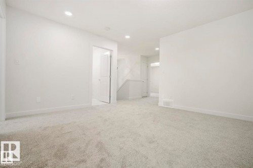 Spacious interior room with light grey carpeting, white painted walls, recessed lighting, and white baseboards - 151 Kidd Crescent, Leduc, AB - Indoor Photo Showing Other Room