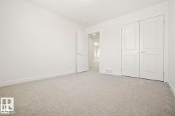 Interior room featuring neutral carpeting, white walls, and a recessed ceiling light fixture - 