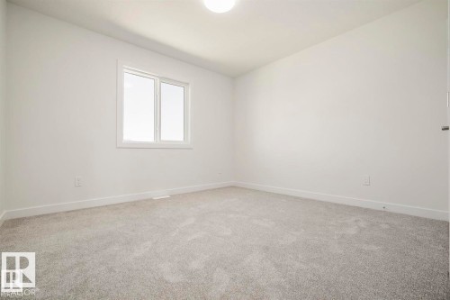 Spacious room with light gray carpeting, a single window with white trim, white walls, and a flush-mount ceiling light fixture - 151 Kidd Crescent, Leduc, AB - Indoor Photo Showing Other Room
