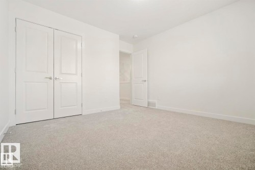 Neutral-toned wall-to-wall carpeting complements bright white walls and trim - 151 Kidd Crescent, Leduc, AB - Indoor Photo Showing Other Room