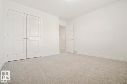 Neutral-toned wall-to-wall carpeting complements bright white walls and trim - 