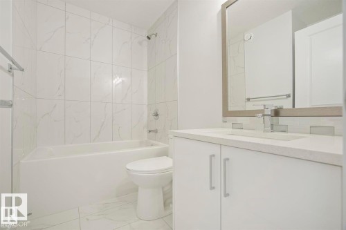 Modern bathroom featuring a white vanity with integrated sink, chrome faucet, and a large framed mirror - 151 Kidd Crescent, Leduc, AB - Indoor Photo Showing Bathroom