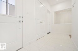 Entryway featuring bright white walls, large format tile flooring, and recessed lighting - 
