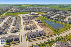 Expansive residential community featuring a variety of housing styles, established streets with sidewalks, and a central pond with a fountain - 