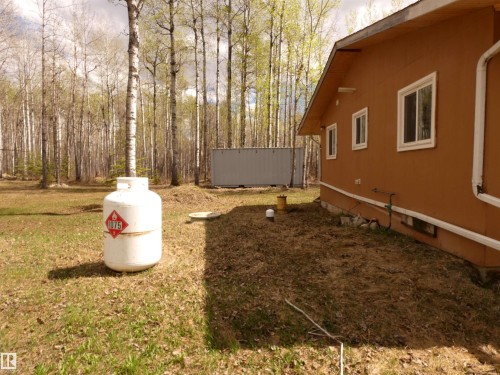 Back view of the cottage; there is a small access panel to underneath, centrally located.  Septic holding tank and water cistern are at the S  rear of the building - 307 Willow Place, Rural Barrhead County, AB 