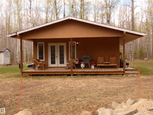 This view is more square-on & shows the garden door entryway. Front porch is covered so you can still sit outside if weather a bit inclement. Birds, deer and other wildlife abound in the area. Deer seem to have a "daily trek" through this area! - 307 Willow Place, Rural Barrhead County, AB 