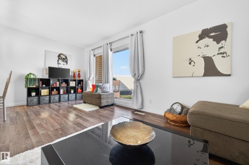 Spacious living area featuring wood-finish flooring, white walls, and bright natural light from a large window - 14522 56 Street, Edmonton, AB - Indoor Photo Showing Living Room