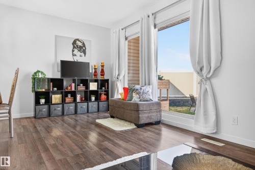 Light-filled room featuring wood-finish flooring, white walls, and a large sliding glass door - 14522 56 Street, Edmonton, AB - Indoor Photo Showing Living Room
