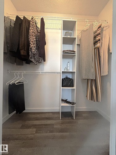 Custom closet system featuring wire shelving, multiple hanging rods, and an integrated vertical storage unit with five shelves - 14522 56 Street, Edmonton, AB - Indoor With Storage