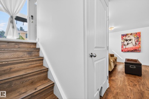 Wood-look vinyl plank staircase and wall-mounted white handrail - 14522 56 Street, Edmonton, AB - Indoor Photo Showing Other Room