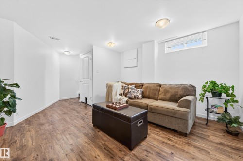 Finished lower level featuring wood-look vinyl plank flooring, white walls and doors - 14522 56 Street, Edmonton, AB - Indoor Photo Showing Living Room