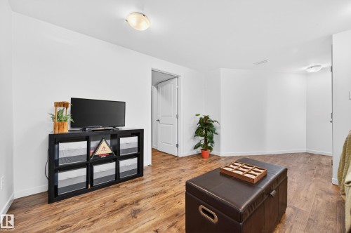 Spacious room featuring wood-finish flooring and bright white walls - 14522 56 Street, Edmonton, AB - Indoor