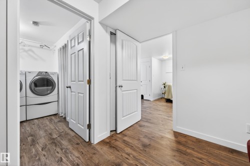 Doorway to finished laundry room featuring wood-look vinyl plank flooring and white painted walls - 14522 56 Street, Edmonton, AB - Indoor Photo Showing Laundry Room