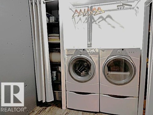 Laundry area featuring a pedestal based washer and dryer, adjacent shelving, and a rod for hang-drying delicate clothes - 14522 56 Street, Edmonton, AB - Indoor Photo Showing Laundry Room