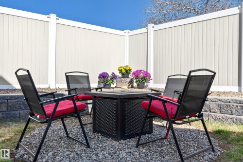 Outdoor seating area featuring a gravel base, retaining wall, and full-height privacy fencing - 14522 56 Street, Edmonton, AB - Indoor Photo Showing Office