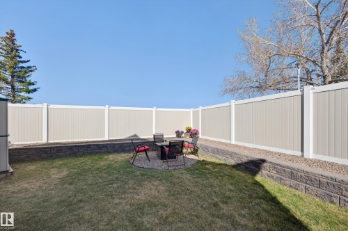 Enclosed backyard featuring a manicured lawn, a gravel patio area, and a privacy fence - 14522 56 Street, Edmonton, AB - Outdoor