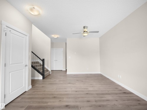 Open-concept interior featuring wood-finish flooring, light neutral wall tones, and white trim - 8921 217 Street Nw, Edmonton, AB - Indoor Photo Showing Other Room