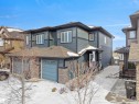 Contemporary two-story exterior featuring dark blue siding with lighter blue accents and stone veneer details - 8921 217 Street Nw, Edmonton, AB  - Outdoor 