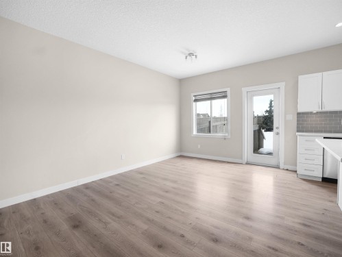 Spacious living area featuring wood-finish flooring, white baseboards, and neutral wall tones - 8921 217 Street Nw, Edmonton, AB - Indoor Photo Showing Kitchen
