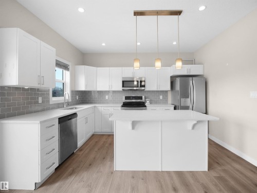 Kitchen featuring white shaker cabinetry, stainless steel appliances, a subway tile backsplash, and an island with pendant lighting - 8921 217 Street Nw, Edmonton, AB - Indoor Photo Showing Kitchen With Upgraded Kitchen