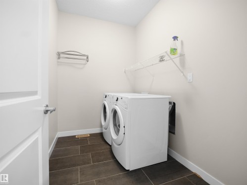 Dedicated laundry area featuring a front-loading washer and dryer set - 8921 217 Street Nw, Edmonton, AB - Indoor Photo Showing Laundry Room