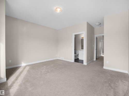 Spacious room featuring neutral carpeting and light-toned wall paint - 8921 217 Street Nw, Edmonton, AB - Indoor Photo Showing Other Room
