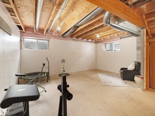 Unfinished basement space with exposed wooden joists and concrete flooring, offering significant potential - 8921 217 Street Nw, Edmonton, AB - Indoor Photo Showing Basement