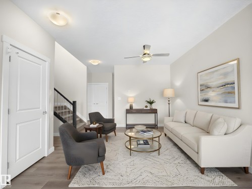 Spacious living area featuring wood-finish flooring, a ceiling fan with integrated lighting, and multiple flush-mount ceiling lights - 8921 217 Street Nw, Edmonton, AB - Indoor Photo Showing Living Room