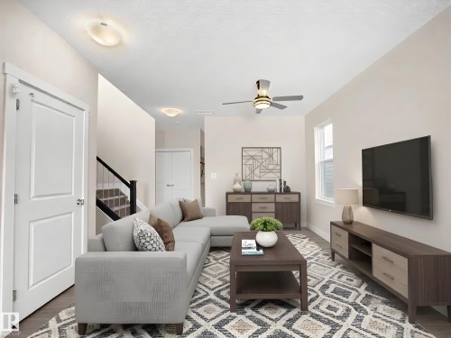 Living area featuring wood-finish flooring, a ceiling fan with integrated lighting, and multiple windows - 8921 217 Street Nw, Edmonton, AB - Indoor Photo Showing Living Room