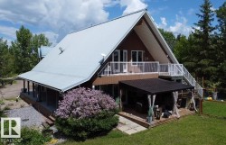 A-frame inspired home featuring a durable metal roof and a spacious upper-level deck with white railing - 