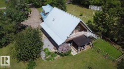 A-frame residence featuring a light-colored metal roof and dark wood siding - 